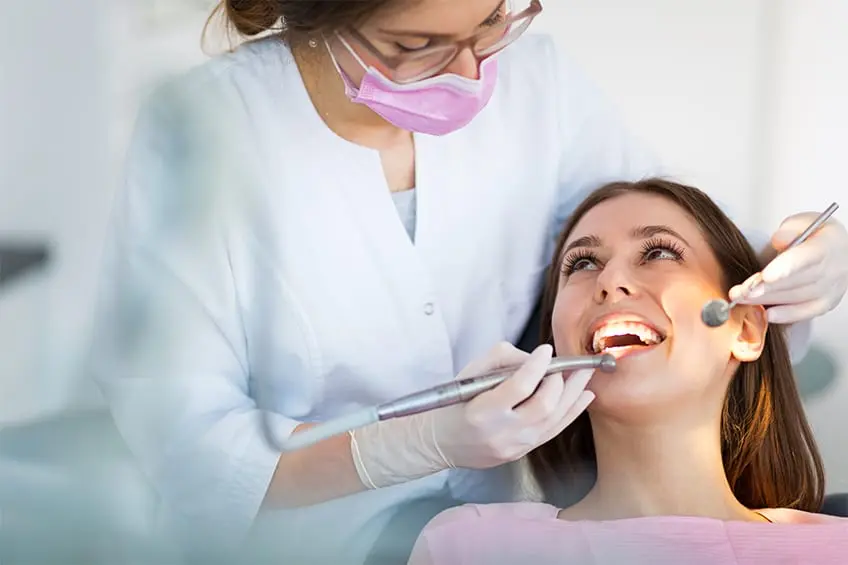 A dental chair and overhead light in a treatment room