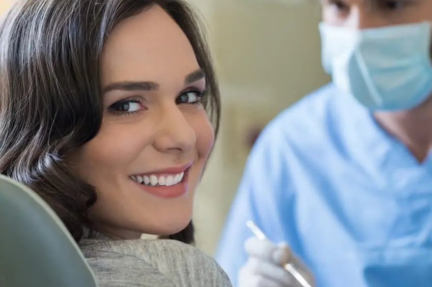 A shade guide held against a patient's teeth
